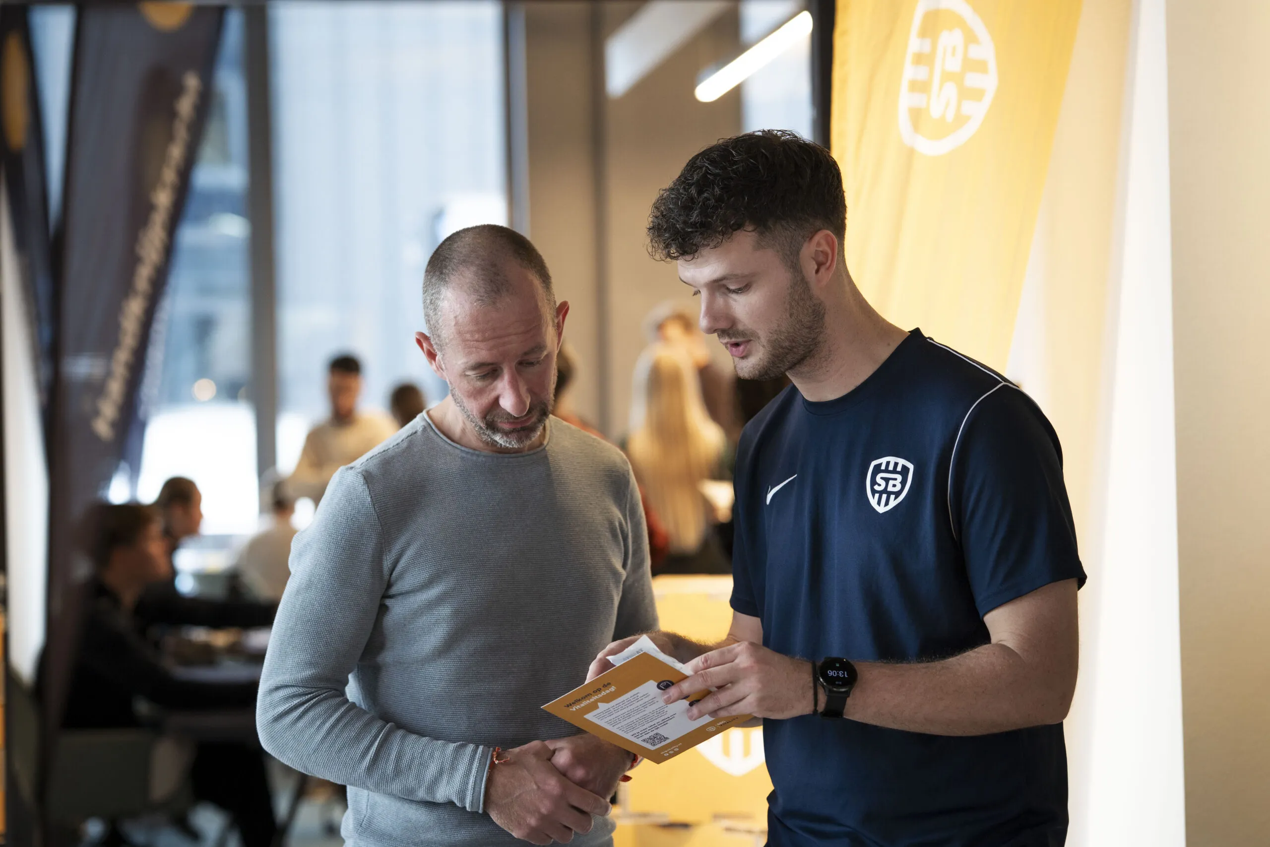 Medewerker die uitleg geeft over het scoreformulier die je krijgt om alle testuitslagen op te schrijven